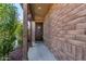 Inviting entryway with brick siding, wooden supports, and a dark wood front door at 9341 W Willow Bend Ln, Phoenix, AZ 85037