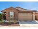 Inviting single-story home featuring a two-car garage, brick accents, and tidy landscaping at 9341 W Willow Bend Ln, Phoenix, AZ 85037