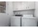 Bright laundry room with white cabinetry, washer, and dryer; convenient and functional at 10105 W Bolivar Dr, Sun City, AZ 85351