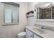 Cozy bathroom with a single sink, mirror, and natural lighting and industrial style shelf at 10218 W Forrester Dr, Sun City, AZ 85351