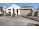 Single-story home with a white stucco exterior, red tile roof, two car garage and xeriscaped front yard at 10242 E Sable Ave, Mesa, AZ 85212