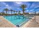 Stunning community pool surrounded by palm trees, lounge chairs and clear blue skies at 10242 E Sable Ave, Mesa, AZ 85212