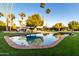 Backyard featuring a sparkling pool, lush lawn, and outdoor fireplace creates a relaxing and inviting outdoor space at 10243 N 58Th Pl, Paradise Valley, AZ 85253