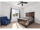 Cozy bedroom featuring a dark wood bed frame, blue accent chair, and natural light from the window at 10464 Magnolia Rd, Gold Canyon, AZ 85118