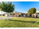 Charming single-story home with a large carport, manicured lawn, and mature shade trees at 10808 W Kelso Dr, Sun City, AZ 85351
