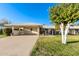 Inviting single-story home with a spacious carport, lush front yard, and mature shade tree at 10808 W Kelso Dr, Sun City, AZ 85351