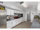 Functional kitchen with white cabinets, tiled backsplash, and ample counter space at 10808 W Kelso Dr, Sun City, AZ 85351