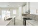 Bright kitchen featuring white cabinetry, mosaic backsplash, stainless appliances, and a pendant light at 11416 S 208Th Ave, Buckeye, AZ 85326