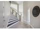 Modern entryway with sleek staircase, gray tile floors, and elegant wall decor at 11537 W Laurelwood Ln, Avondale, AZ 85392