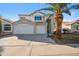 Two-story stucco home with a three car garage and a mature palm tree in the front yard at 11537 W Laurelwood Ln, Avondale, AZ 85392