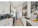 Bright, white kitchen with stainless steel appliances, a large sink, and a tiled backsplash at 11537 W Laurelwood Ln, Avondale, AZ 85392