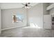 Well-lit primary bedroom with ceiling fan, large window, light gray floors and neutral colored walls at 11537 W Laurelwood Ln, Avondale, AZ 85392