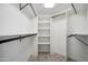 Walk-in closet with white walls, shelving, hanging racks, and tile flooring in a light gray tone at 11537 W Laurelwood Ln, Avondale, AZ 85392