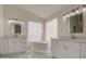 Bright bathroom showcasing dual vanities, a soaking tub, and marble floors at 1349 E Rock Wren Rd, Phoenix, AZ 85048