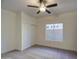 A well-lit bedroom boasts carpeted floors, a ceiling fan, and a large window with sliding closet doors at 1349 E Rock Wren Rd, Phoenix, AZ 85048
