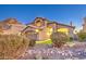 Charming two-story home with a well-manicured front yard landscape, gravel and desert plants at dusk at 1349 E Rock Wren Rd, Phoenix, AZ 85048