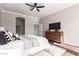 Bright bedroom with ceiling fan, TV, dresser, and an open doorway showcasing the home's layout at 1357 E Loma Vista St, Gilbert, AZ 85295