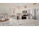 Well-lit kitchen with stainless steel appliances, granite counters, and white cabinetry at 14917 W Yosemite Dr, Sun City West, AZ 85375