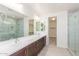 Modern bathroom featuring dual sinks, wood cabinets, and a glass-enclosed shower for a spa-like experience at 20941 E Via Del Sol St, Queen Creek, AZ 85142