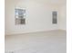 An airy bedroom displays white tile flooring, white walls and two large windows at 20941 E Via Del Sol St, Queen Creek, AZ 85142