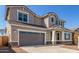 Two-story home shows off a gray garage door, neutral stucco, and manicured front yard at 20941 E Via Del Sol St, Queen Creek, AZ 85142