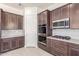 Modern kitchen featuring stainless steel oven, dark wood cabinets, and quartz countertops at 20941 E Via Del Sol St, Queen Creek, AZ 85142