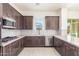 Well-equipped kitchen with stainless steel appliances, dark wood cabinets, and tile backsplash at 20941 E Via Del Sol St, Queen Creek, AZ 85142