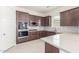 Stylish kitchen boasting built-in appliances, dark wood cabinets, and quartz countertops at 20941 E Via Del Sol St, Queen Creek, AZ 85142