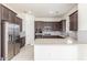 Modern kitchen featuring stainless steel appliances, dark wood cabinets, and quartz countertops at 20941 E Via Del Sol St, Queen Creek, AZ 85142
