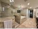 Luxurious bathroom featuring a glass-enclosed shower, soaking tub, and elegant chandelier at 2211 E Camelback Rd # 306, Phoenix, AZ 85016