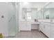 Bright bathroom featuring a shower with a glass door, double sinks, and modern fixtures at 24385 N 173Rd Ln, Surprise, AZ 85387