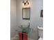 Stylish powder room featuring a unique glass sink, modern mirror, and contemporary lighting at 247 W Maya Dr, Litchfield Park, AZ 85340