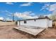 View of the home's backyard with a square concrete patio, block walls, and white exterior under a blue sky at 2904 W Coolidge St, Phoenix, AZ 85017
