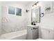 Stylish bathroom with marble wall tiles, modern vanity, and tub, offering a spa-like experience at 2904 W Coolidge St, Phoenix, AZ 85017