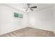 Minimalist bedroom featuring neutral carpet, white walls, a bright window, and ceiling fan at 2904 W Coolidge St, Phoenix, AZ 85017