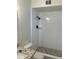 Updated bathroom featuring a tiled walk-in shower with sleek, matte black fixtures and pebble stone flooring at 2958 E Contessa St, Mesa, AZ 85213