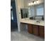 Bathroom vanity featuring a white countertop, dark wood cabinetry, modern lighting and mirror at 3010 E Cedar Dr, Chandler, AZ 85249