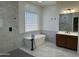 Bright bathroom with a soaking tub, glass block window, vanity, modern fixtures, and marble-look tile at 3010 E Cedar Dr, Chandler, AZ 85249
