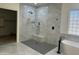 Modern bathroom featuring a glass block window, marble style tile walls, and sleek black matte fixtures at 3010 E Cedar Dr, Chandler, AZ 85249