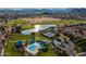 Overhead view of a community pool, tennis courts, and lake surrounded by beautiful desert mountain scenery at 30263 N Bobcat Way, San Tan Valley, AZ 85143