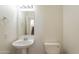 A powder room with a pedestal sink, toilet, mirror, and towel rack at 30263 N Bobcat Way, San Tan Valley, AZ 85143