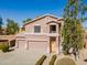 Two-story home featuring a three-car garage, neutral stucco and tile roof with manicured shrubs along the walkway at 30263 N Bobcat Way, San Tan Valley, AZ 85143