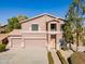 Two-story home featuring a three-car garage, neutral stucco and tile roof with manicured shrubs along the walkway at 30263 N Bobcat Way, San Tan Valley, AZ 85143
