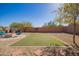 Landscaped backyard featuring artificial turf, decorative pavers, and an outdoor fireplace at 317 W Settlers Trl, Casa Grande, AZ 85122