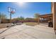 Large backyard featuring a basketball hoop, fire pit area, grassy patch and covered patio at 317 W Settlers Trl, Casa Grande, AZ 85122