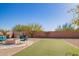 Large backyard with artificial turf, desert landscaping, a firepit, and block fencing at 317 W Settlers Trl, Casa Grande, AZ 85122