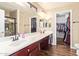 Ensuite bath features double sinks, custom cabinetry, walk-in closet and shower with decorative tiling at 317 W Settlers Trl, Casa Grande, AZ 85122