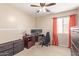 This is a bedroom that features a ceiling fan, computer desk, and window with coral curtains at 317 W Settlers Trl, Casa Grande, AZ 85122