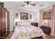 Warm, inviting bedroom with a ceiling fan, and a brightly colored floral comforter set at 317 W Settlers Trl, Casa Grande, AZ 85122