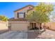 Two story home with an attached garage, desert landscaping and a covered porch seating area at 317 W Settlers Trl, Casa Grande, AZ 85122